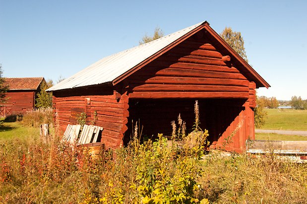 Fjäl 1:22. Timrad, rödmålad byggnad.