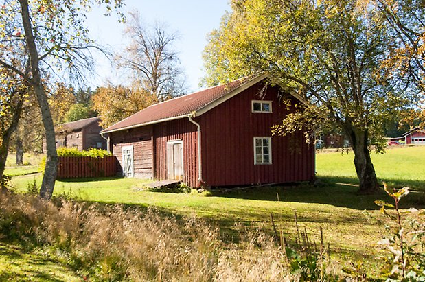 Fjäl 3:43. Byggnad i i röd panel med fönster med spröjs och två dubbelportar.