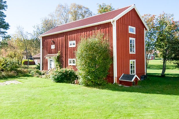 Fjäl 3:43. Hus i två våningar med fönster med vita spröjs och vita och blå dörrar.
