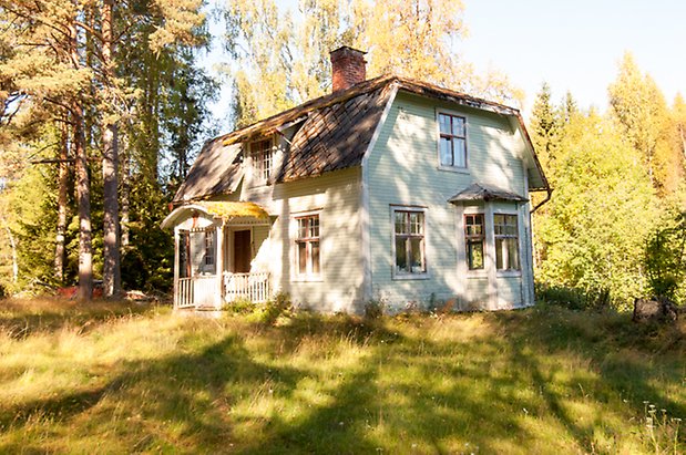 Fjäl 4:7. Villa i vit liggande panel, förstukvist med mossa av tak och fönster med röda spröjs.