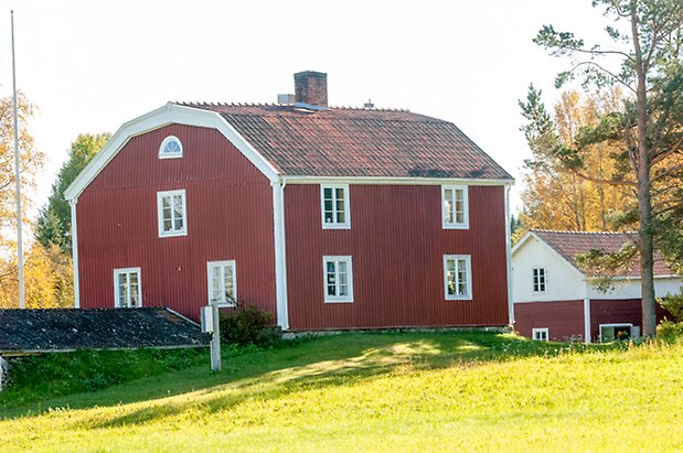 Fjäl 4:11. Villa i tre våningar i röd stående panel med fönster med vita spröjs.