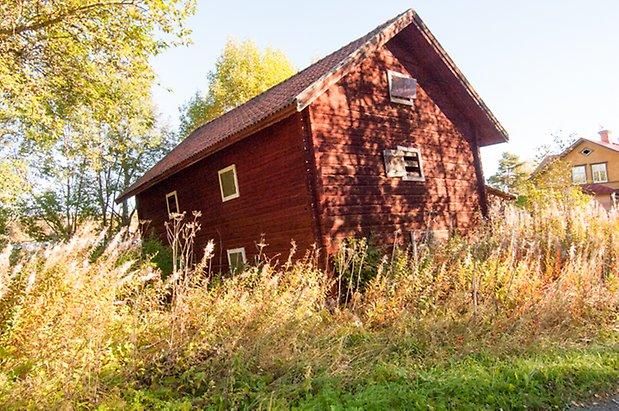 Hölje 1:21. Timrad, rödmålad byggnad med luckor.