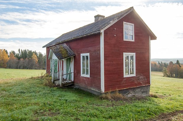 Hölje 4:7. Hus i röd panel i två våningar med grön dörr och dubbeldörrar och fönster med vita spröjs.