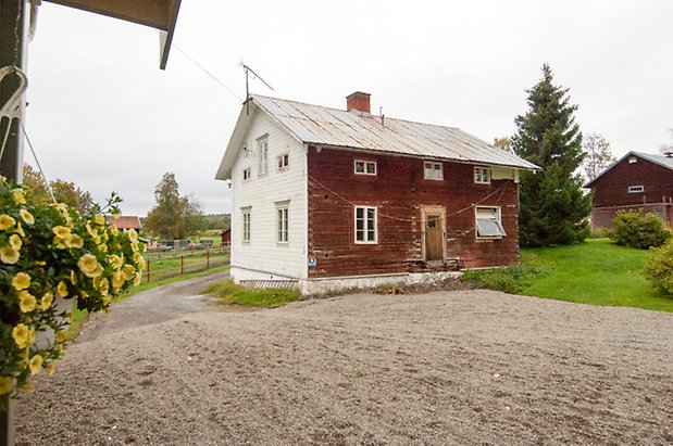 Klösta 2:4. Timrat hus i två våningar, långsida i rött och kortsida i vitt, fönster med vita spröjs.