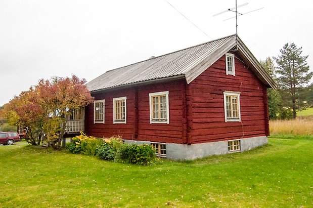 Klösta 3:2. Timrat, rött hus i två våningar på putsad grund, med fönster med gula spröjs. 