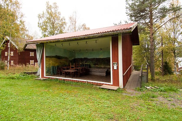 Lits Prästbord 1:18. Byggnad i röd panel med öppen långsida.