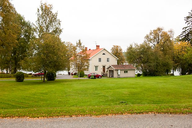 Lits Prästbord 1:18. Villa i två våningar i ljusgul, liggande panel med vita fönster med spröjs.