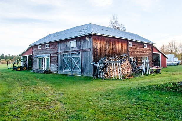 Lits-Åsen 4:6. Byggnad i timmer och panel i brunt. Dubbelport och två gröna dörrar.