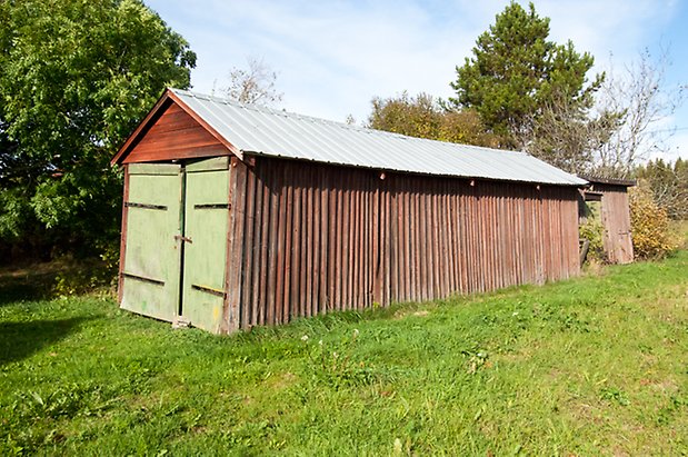 Mo 4:8. Byggnad i röd panel med en grön garage port.