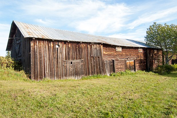 Palleråsen 1:8. Ladugård i två våningar, i brun panel och timmer.