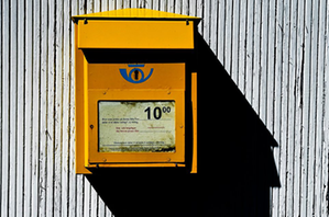 Postens gula brevlåda som hänger på en vägg