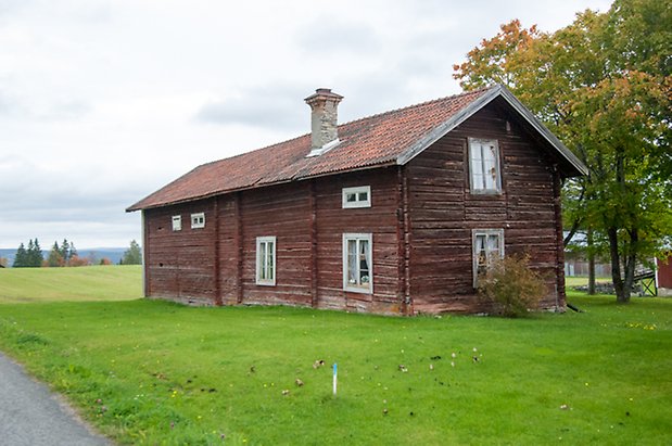 Söre 1:8. Hus i två våningar i rött timmer med en skorsten och fönster med vita spröjs. 