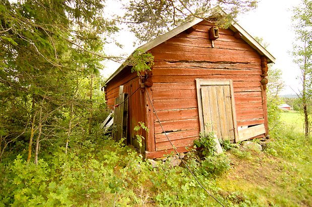 Orrviken 1:6. Timrad, röd byggnad med brun lucka.