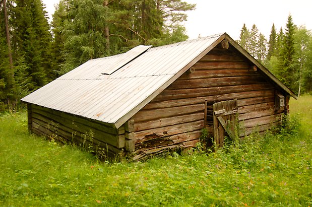 Orrviken 2:12. Låg, brun timrad byggnad.