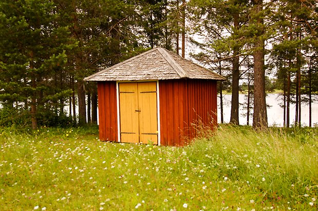 Sunne Prästbord 1:2. Liten fyrkantig byggnad i röd panel med gul dubbelport.