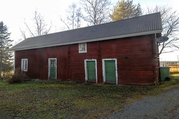 Bjärme 2:1. Byggnad i rött timmer och panel, i två våningar med en grön dörr och två gröna portar och fönster med spröjs.