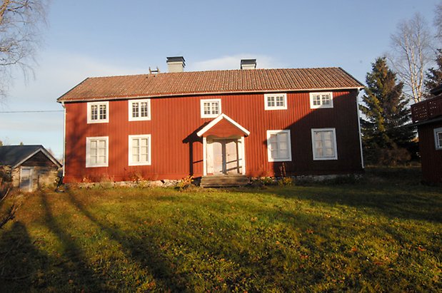 Bjärme 3:1. Hus i två våningar med förstukvist, ljusgrå dubbeldörr med fönster med vita spröjs.