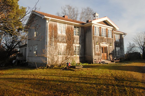 Bjärme 7:3. Hus i två våningar i brun och vit panel med fönster med spröjs.