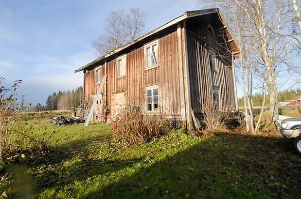 Fåker 3:28. Byggnad i två våningar i grå panel med fönster med spröjs.