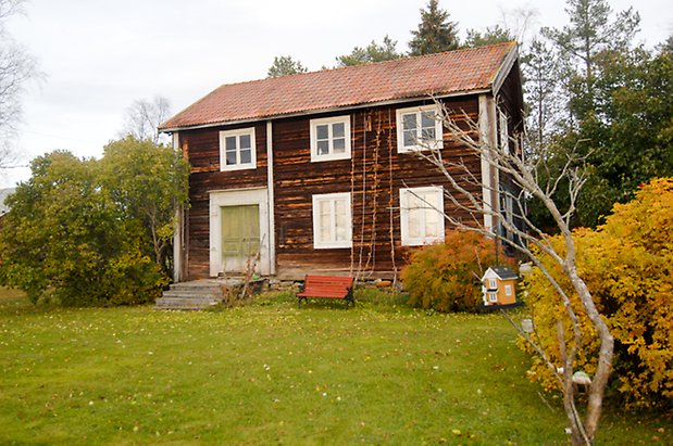 Grönviken 1:4. Hus i brunt timmer med grön dubbeldörr och fönster med vita spröjs.