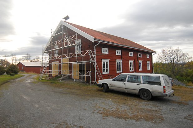 Månsta 2:37. Byggnad i rött timmer i tre våningar, tre gula dubbelportar och fönster med vita spröjs. 