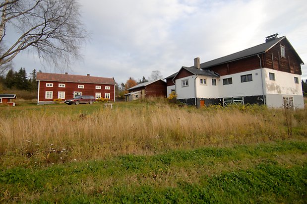 Sinnberg 2:27 Ladugård i vitt och brunt samt rött hus på grådsplan.