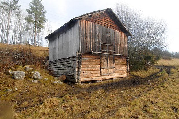 Åsan 1:2. Går byggnad i timmer och panel med dubbelport.