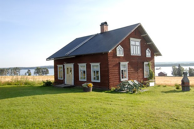 Jälsta 2:1. Hus i rött timmer i två våningar, med ljusgula dubbeldörrar med fönster med vita spröjs.