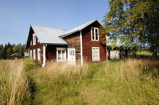 Norderöns-Backen 1:12. Hus i brun panel i två våningar, med vita dubbeldörrar och fönster med vita spröjs.