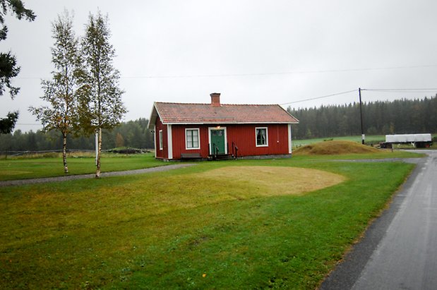 Norderöns Prästbord 1:1. Byggnad i röd, liggande panel med grön dubbeldörr och fönster med gröna spröjs.