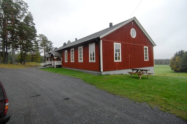 Västanede 2:2. Hus i röd panel med fönster med vita spröjs, med två förstukvistar bredvid varandra.