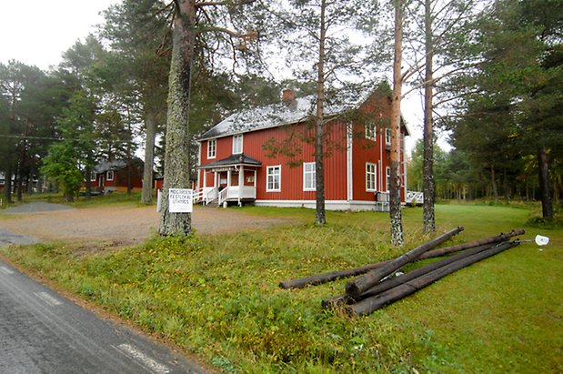 Västanede 4:1. Hus i två våningar i röd panel, vit förstukvist, fönster med vita spröjs.