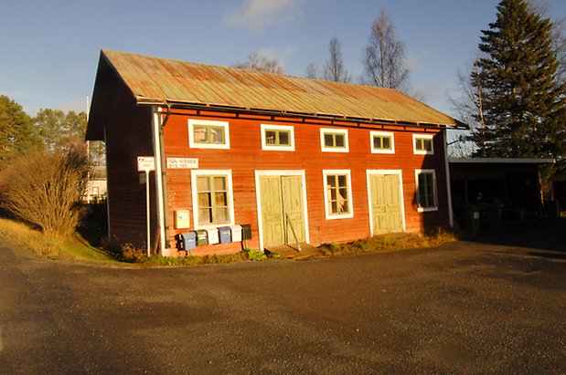 Marieby-Bye 5:1. Byggnad i två våningar i röd, liggande panel med två gröna dubbelportar med fönster med gröna spröjs.