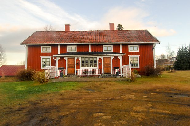 Öd 3:7. Hus i två våningar i röd panel, fönster med gröna spröjs, förstukvist med bruna dörrar.