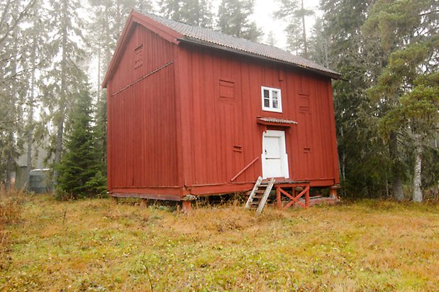 Lungre 1:6. Byggnad i rött panel i två våningar, lite vit dörr, litet fönster med spröjs.