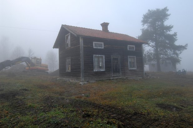 Lungre 2:3. Hus i brunt timmer i två våningar, brun dörr och fönster med spröjs.