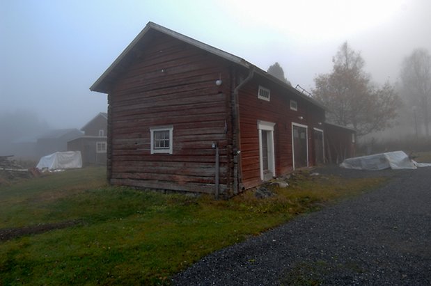 Lungre 2:4. Byggnad i röd/brunt timmer, dörr i svart och två dubbelportar, fönster med spröjs.