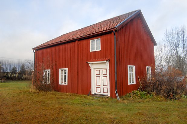 Brynje 2:3. Hus i röd panel med vit dubbeldörr  med röda detaljer och fönster med vita spröjs.