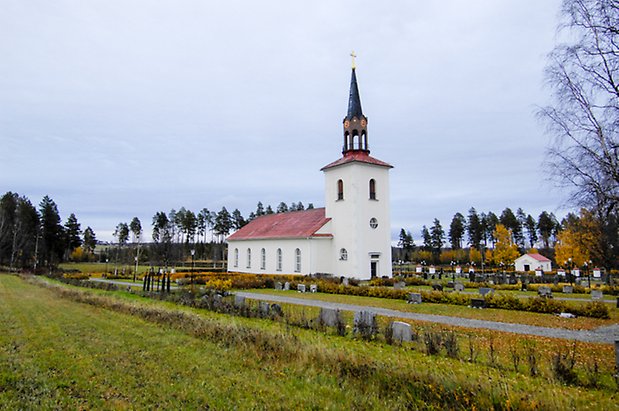 Häggenås Prästbord 1:7. Kyrka i vit puts med rött tak och svart spira.