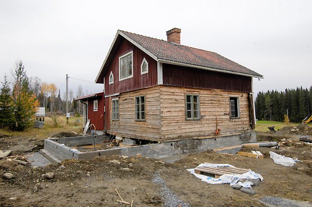 Grötom 1:27. Hus i två våningar som håller på att renoveras, på undervåningen nytt timmer, röd panel på övervåningen, fönster med gröna spröjs.