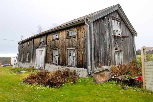 Jonsgård 1:88. Hus i två våningar i grå panel, vit dubbeldörr, fönster med spröjs.