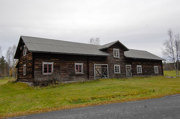 Kogsta 2:27. Ladugård i grått timmer, en dubbelport och en port, takkupa med fönster.