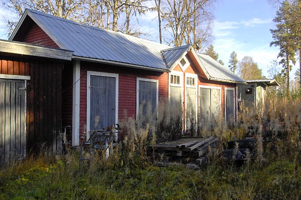 Kogsta 2:50. Byggnad i röd, liggande panel, två dubbelportar och fem portar i blått.