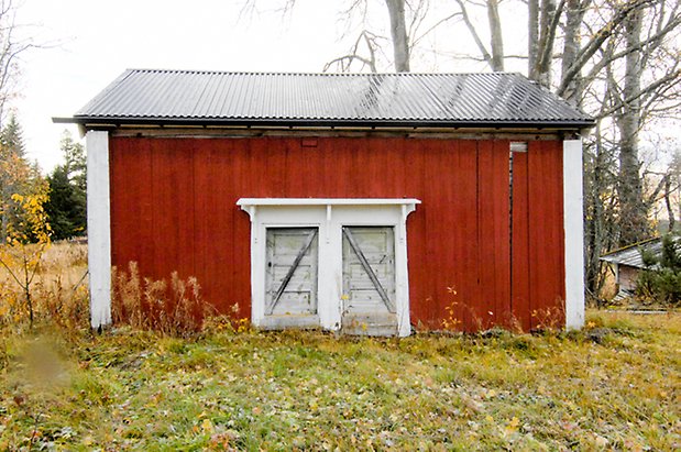 Långkälen 5:24. Byggnad i röd panel med två blå portar.