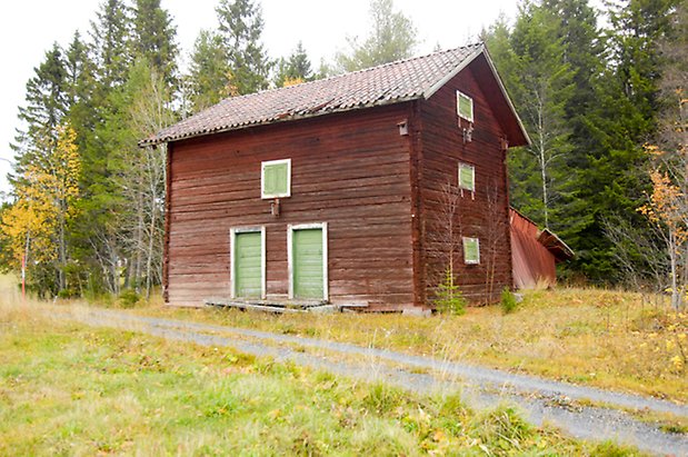 Storgård 1:31. Byggnad i rött timmer i två våningar, två gröna portar och gröna luckor.