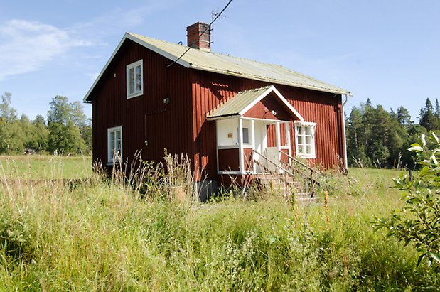 Kungsgården 5:4. Villa i röd panel, fönster med vita spröjs, förstukvist i rött och vitt, vit dörr.