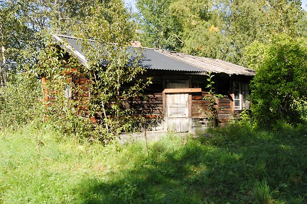 Kungsgården 5:4. Byggnad i brunt timmer, grå port.