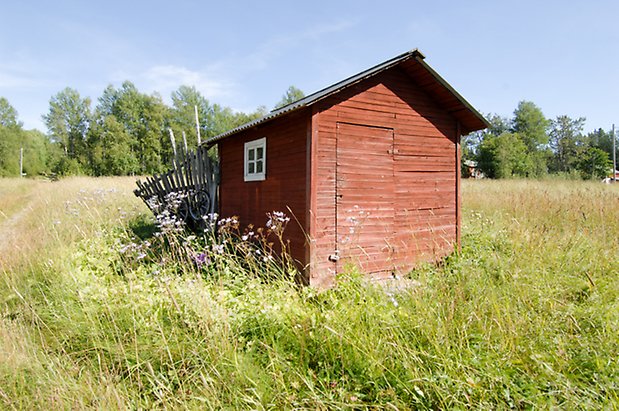 Kungsgården 5:4. Byggnad i röd panel, fönster med vita spröjs, röd port.