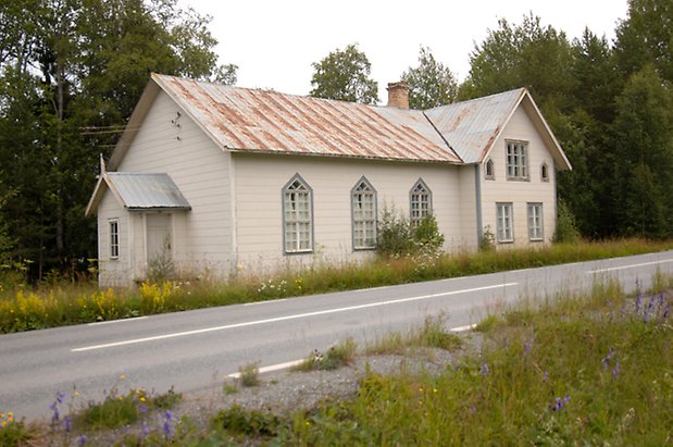 Fillsta 1:15. Byggnad med vit panel med ljusblå detaljer, i två våningar. Spetsiga fönster med vita spröjs.