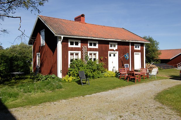 Frösö Prästbord 1:7. Hus i röd panel med vita detaljer, fönster med vita spröjs, vit dubbeldörr, vit port.